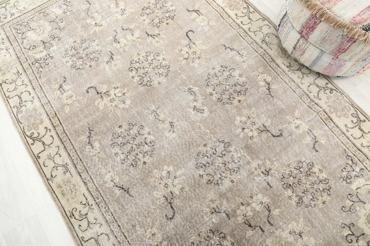Close-up of the rug's tan field with gray and charcoal floral and medallion patterns