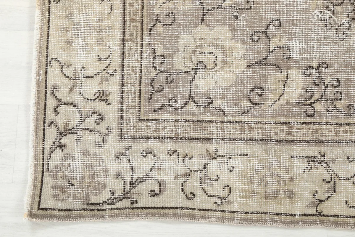 Corner detail showing the beige border with geometric patterns and the charcoal outlines
