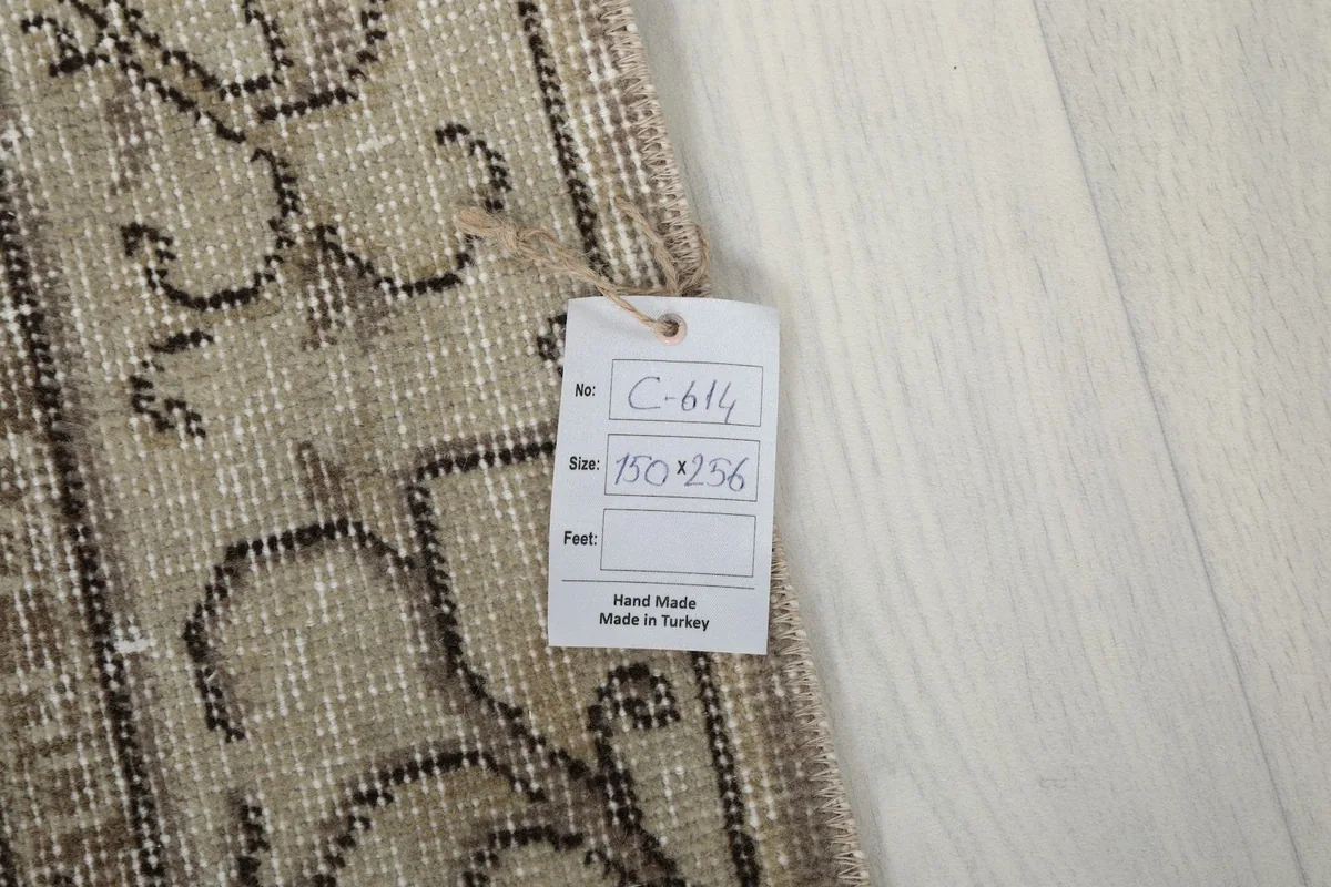 Close-up of the rug's reverse side with a tag showing size and 'Hand Made in Turkey' label