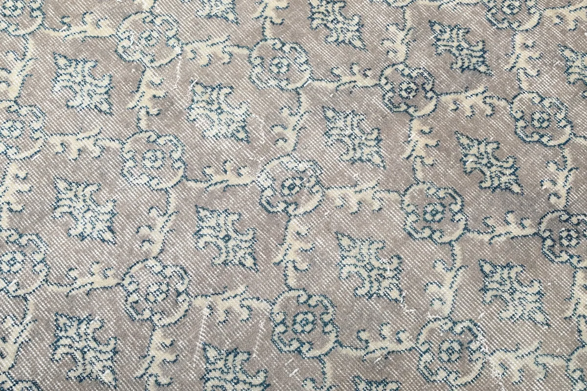 Detailed close-up of the tan, blue, and ivory geometric pattern and wool pile