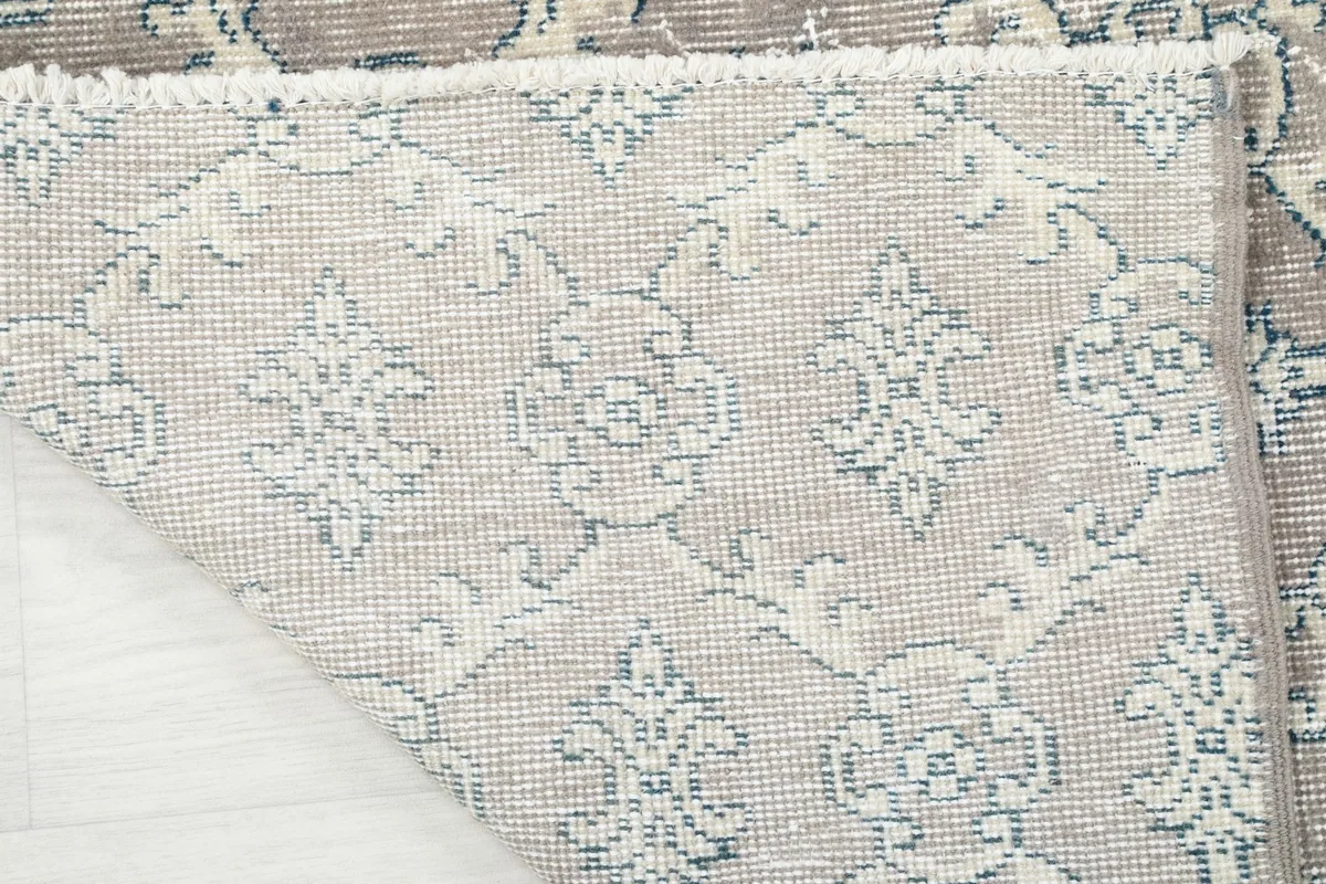 Detailed view of the rug's reverse side, revealing the hand-knotted cotton foundation