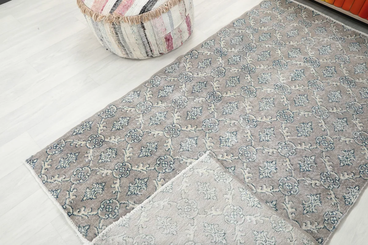 View of the rug folded back to show the cotton foundation and reverse side