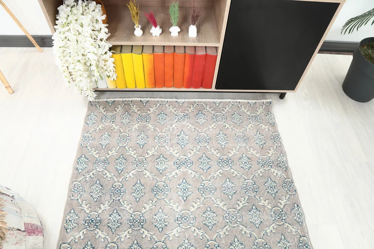 Overhead shot of the tan and blue geometric rug, highlighting the full pattern