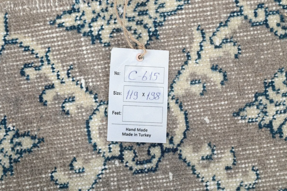 Close-up of the rug's texture with a product tag showing size and handmade origin