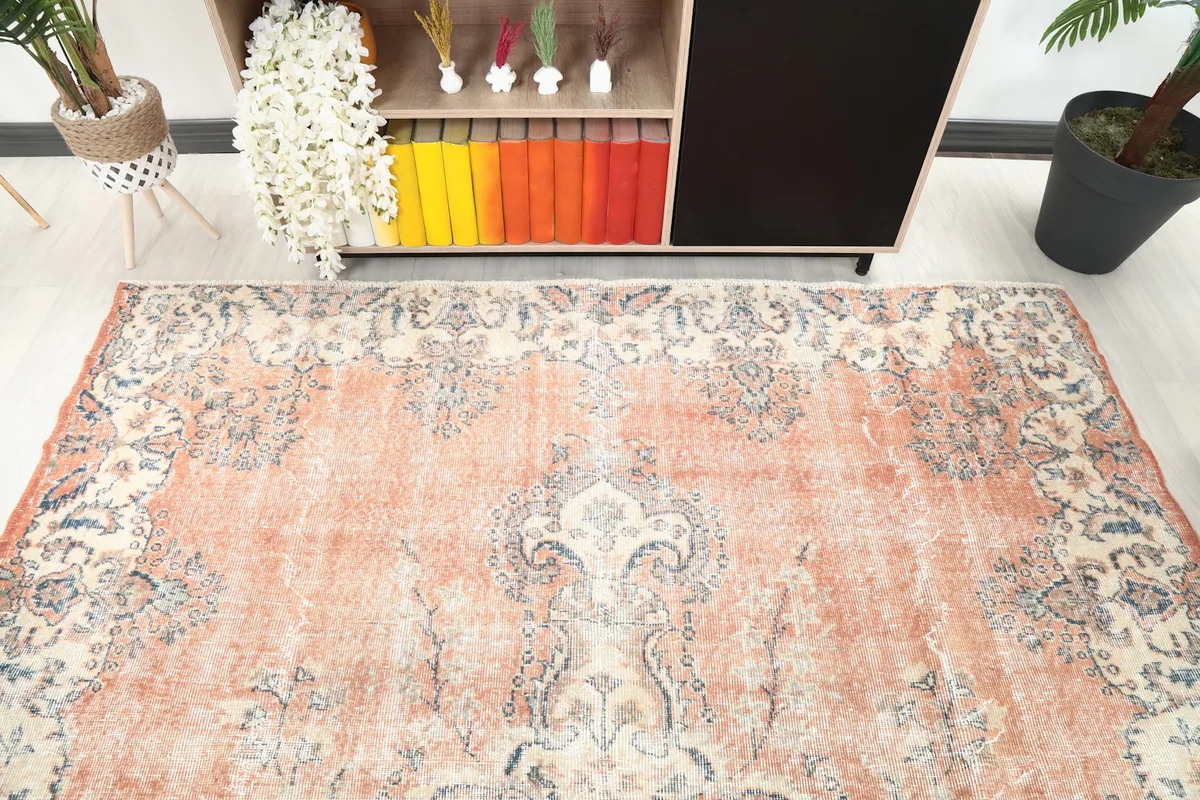 Detail of the rug's border and field pattern in a room setting, showing color variation.