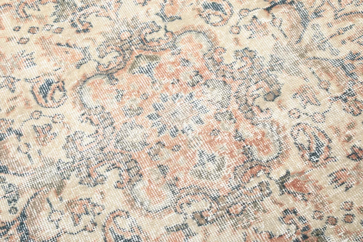 Close-up detail of the rug's pattern, showing the hand-knotted texture and natural wear.