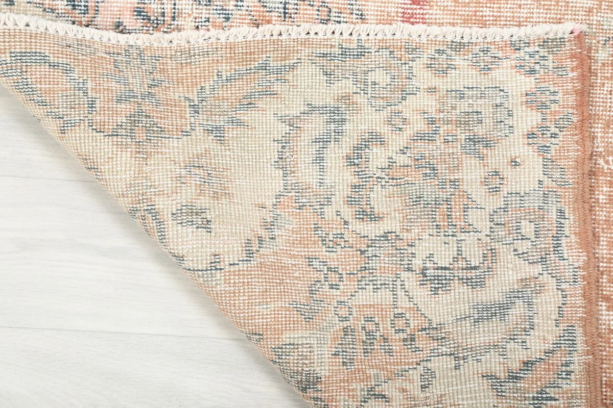 Close-up of the rug's folded corner, showing the wool pile and cotton foundation.
