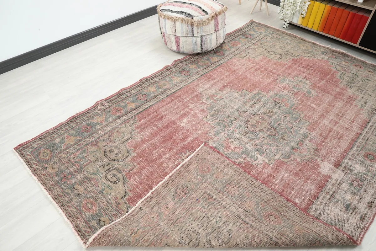 A corner of the rug folded back, showing the back of the hand-knotted construction