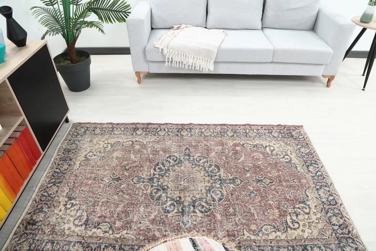 View of the vintage rose and navy rug from an elevated angle, showing its full length in the room.