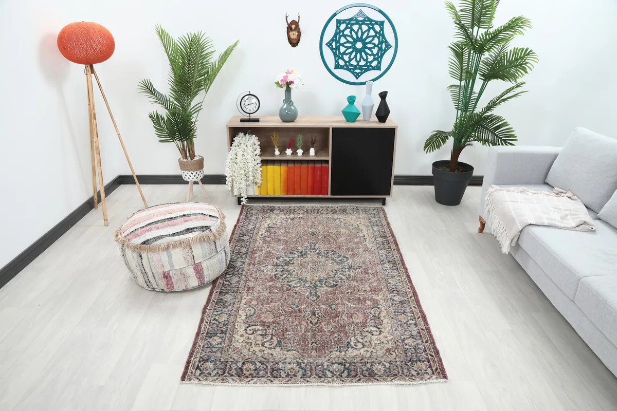 Vintage rose and navy area rug displayed in a bright modern living room setting with a light sofa.