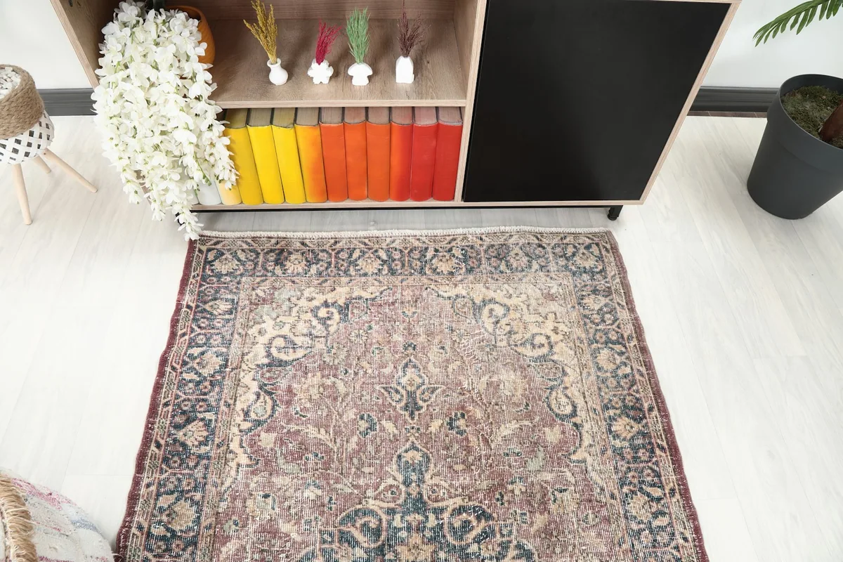 Overhead perspective of the rose and navy area rug, highlighting its central medallion design.