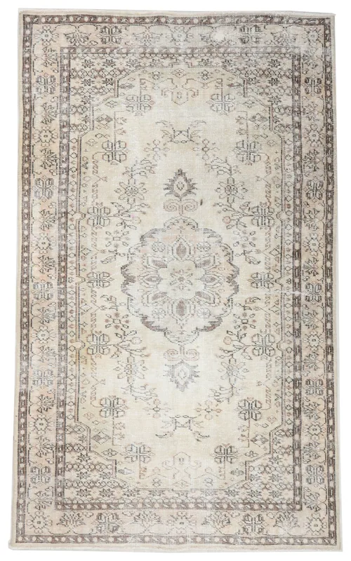 Full top view of the 5'2" x 8'11" ivory and beige vintage Anatolian rug with a central medallion