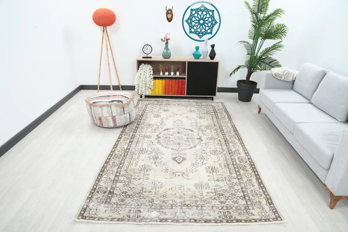 Vintage Anatolian rug displayed in a living room setting with a light gray sofa and wooden furniture