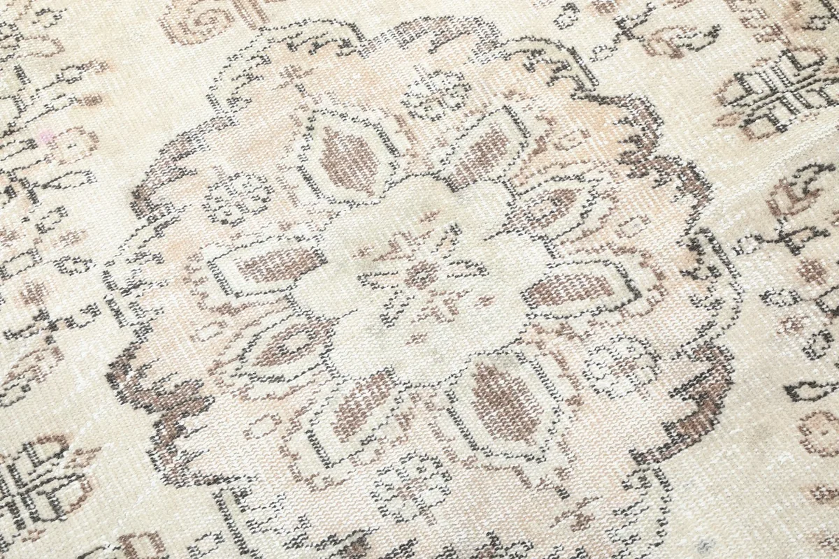 Detailed view of the rug's central medallion, showing softened colors and subtle wear