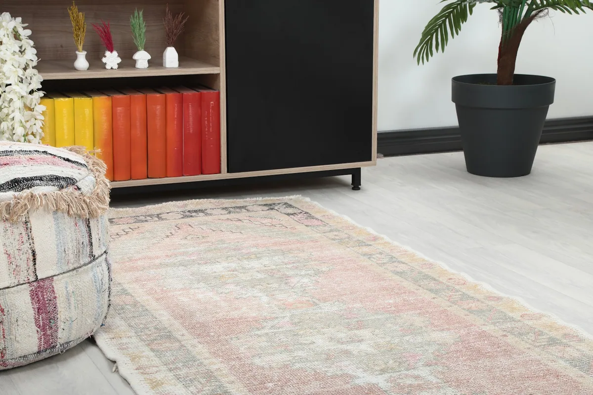 Close-up view of one end of the runner rug, showing it alongside a decorative ottoman and shelving.