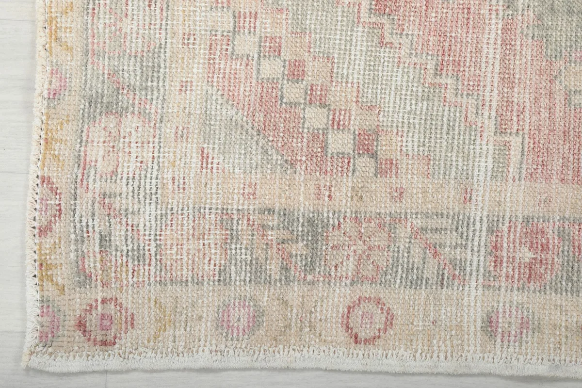 Close-up of the rug's end, highlighting the border design and subtle fringe.