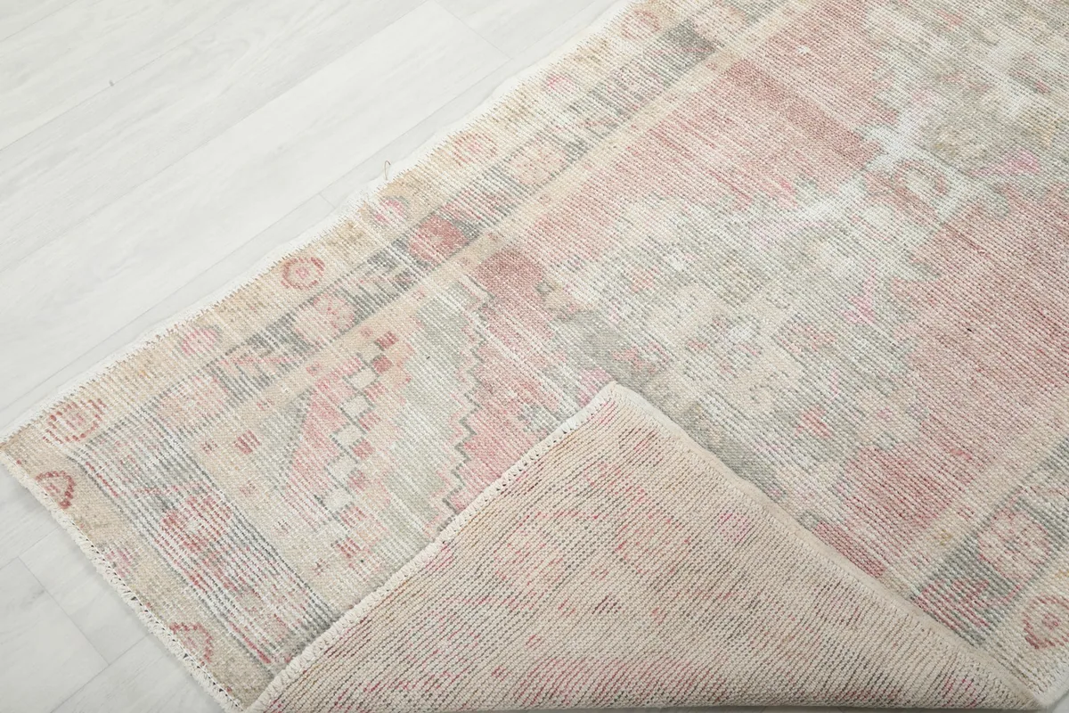 Corner of the rug folded back, showing the thickness and construction.