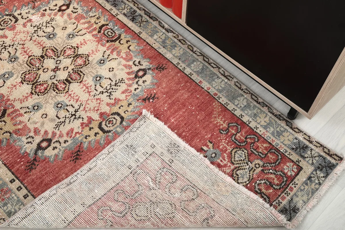View of the rug's underside, revealing the hand-knotted cotton foundation and wool pile
