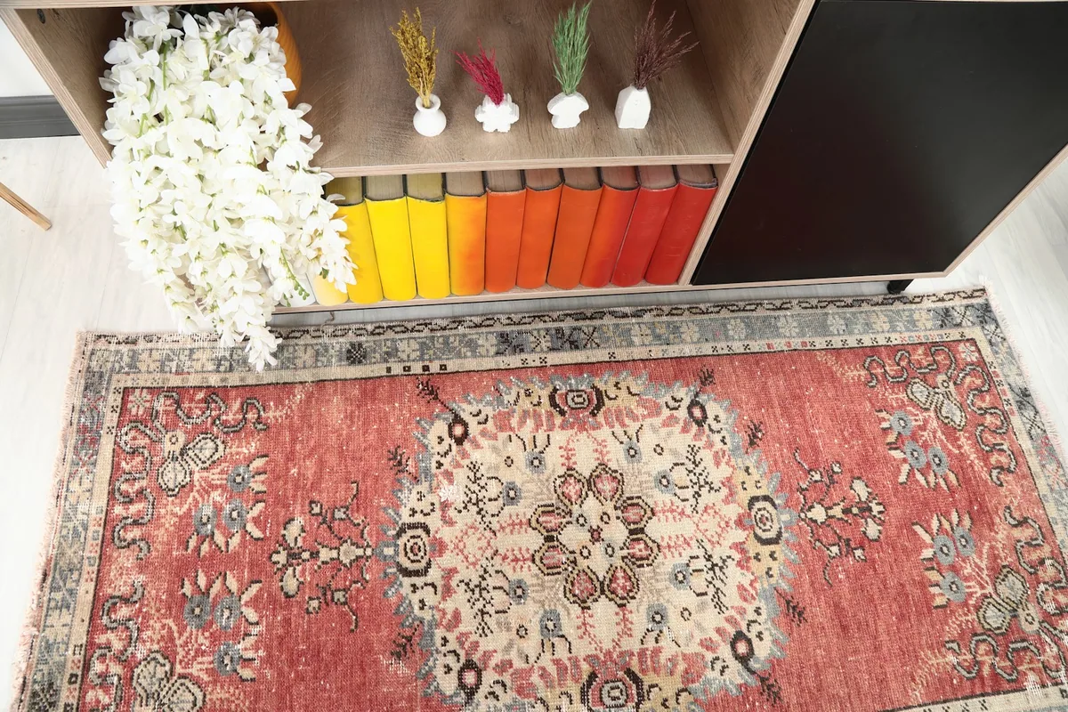 Direct overhead shot of the rust rug's central medallion and surrounding patterns