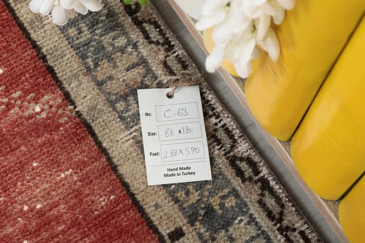 Tag showing the rug's dimensions and origin, placed on the rug's border