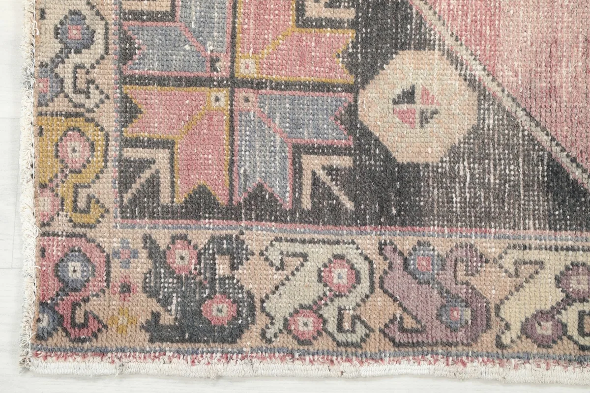 Close-up of the border design featuring colorful tribal patterns and the rug's edge
