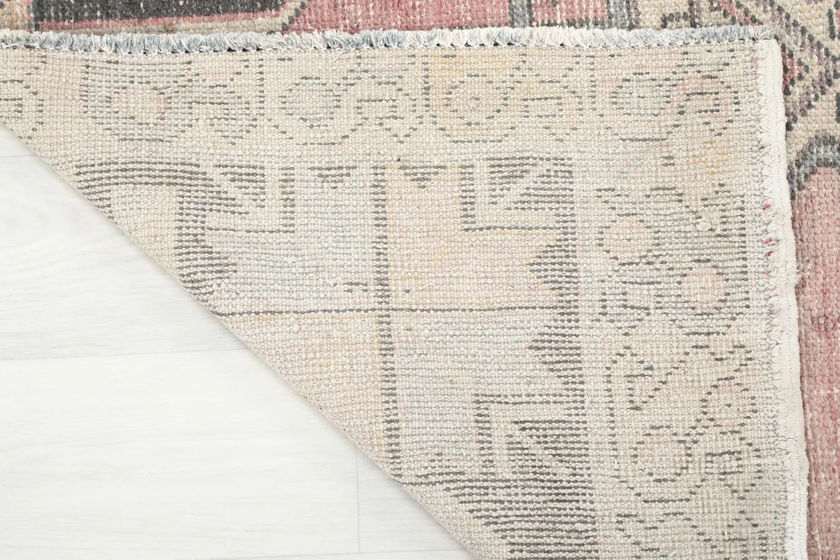 Detailed view of the rug's back, revealing the intricate hand-knotted structure and foundation