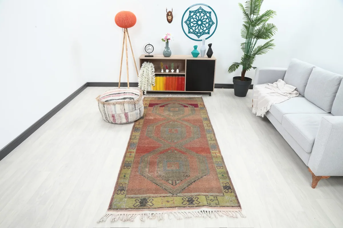 Vintage rust geometric runner rug in a modern living room setting with a couch and decor.