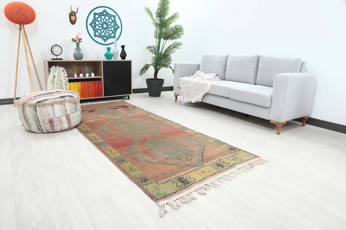 Angled view of the rust runner rug in a living space, showcasing its length and colors.