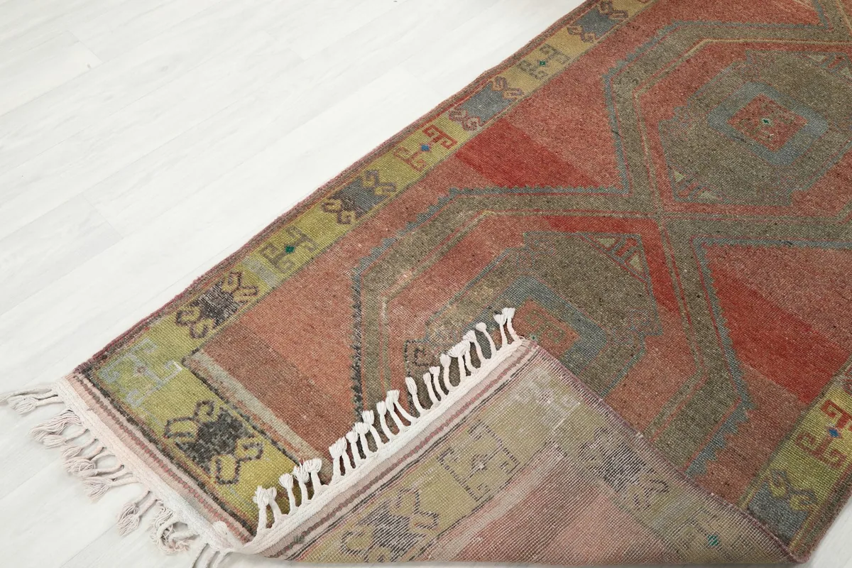 View of the rug folded to show the thickness and flexibility of the vintage hand-knotted wool.