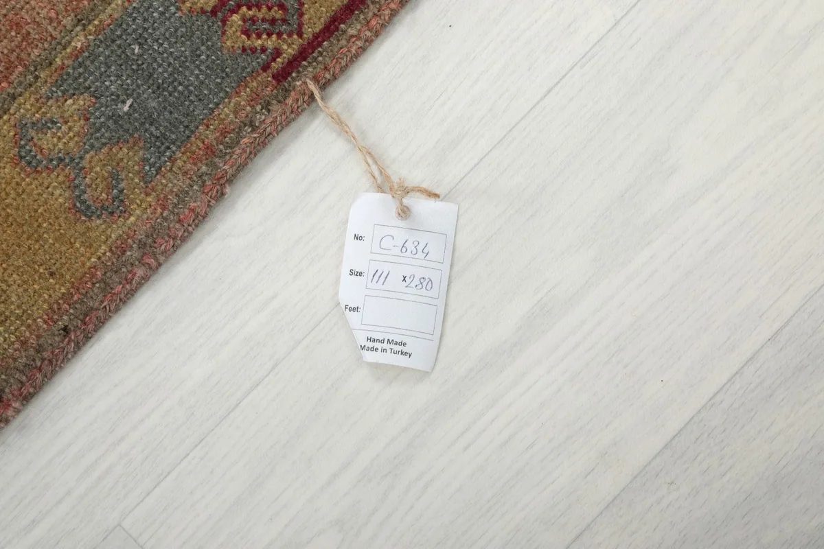 Close-up of the size tag attached to the rug, showing its dimensions in centimeters.