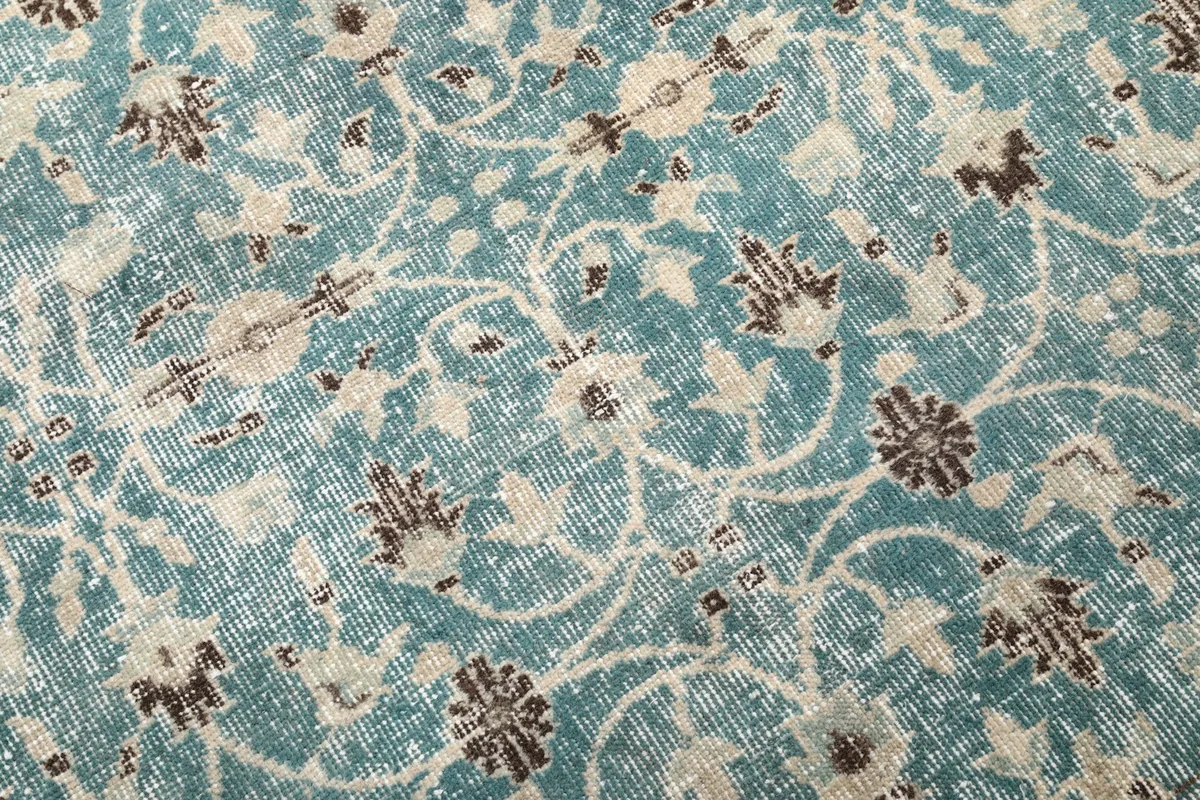 Detailed close-up of the blue rug's floral motifs and visible low pile