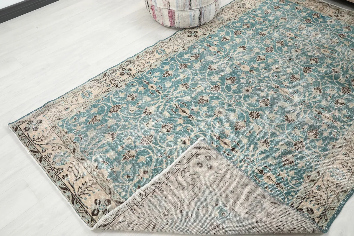 Corner of the rug folded back to show the cotton foundation and reverse side
