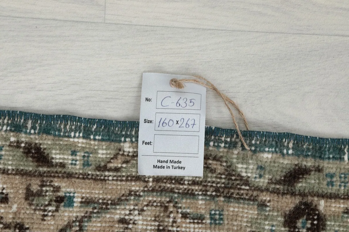 Rug tag showing the size in centimeters and confirming handmade origin from Turkey
