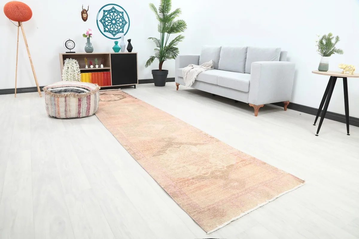 Angled view of the rose runner rug in a hallway, highlighting its texture and faded design.