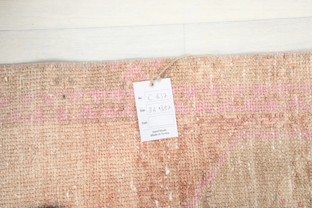 Close-up of the rug's surface with an information tag, showing material and origin details.