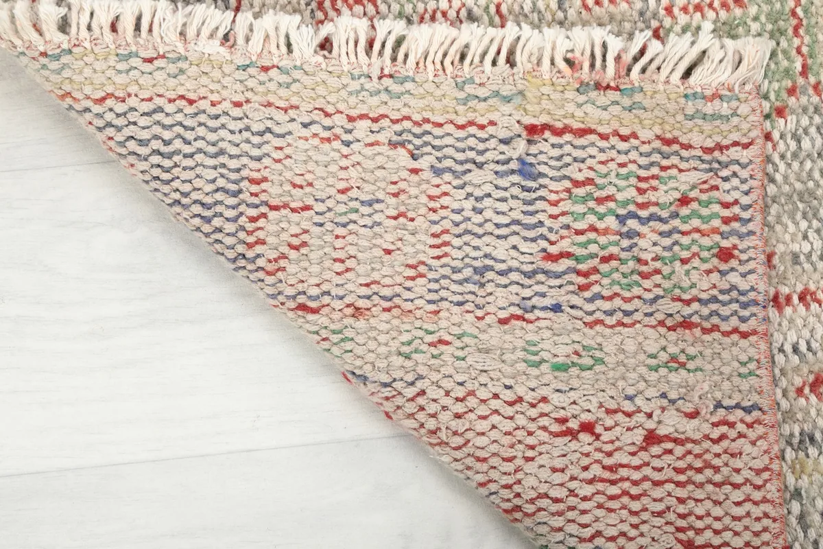Underside view of the hand-knotted rug, revealing the cotton foundation and the craftsmanship of the knots.
