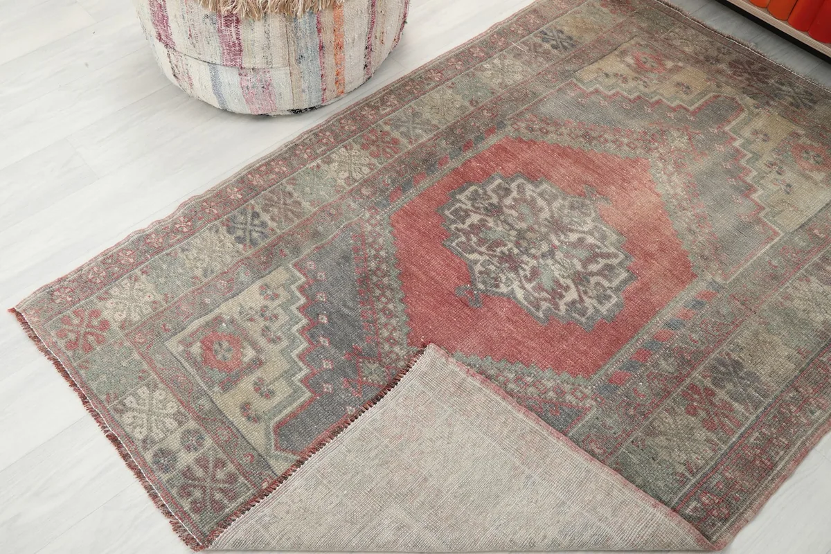 Rug partially folded back to reveal the cotton foundation and the reverse side of the hand-knotted weave.