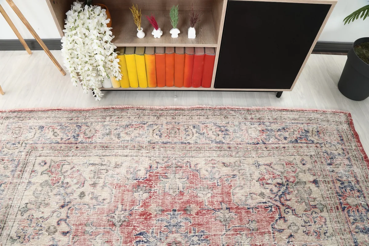 Detail of the rug's border and field patterns, shown in a room setting near furniture