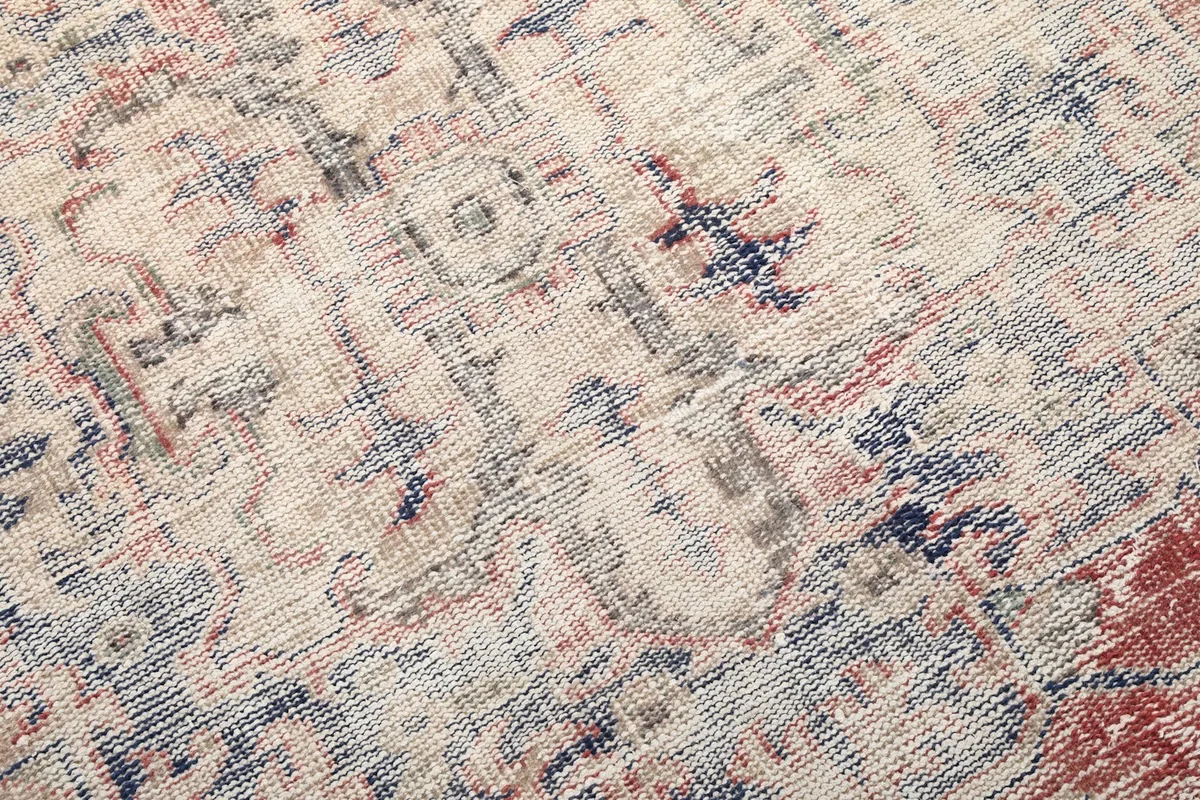 Detailed view of the intricate geometric and floral motifs within the rug's field