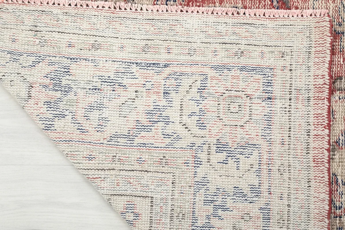Detail of the back of the hand-knotted wool rug, revealing the cotton foundation
