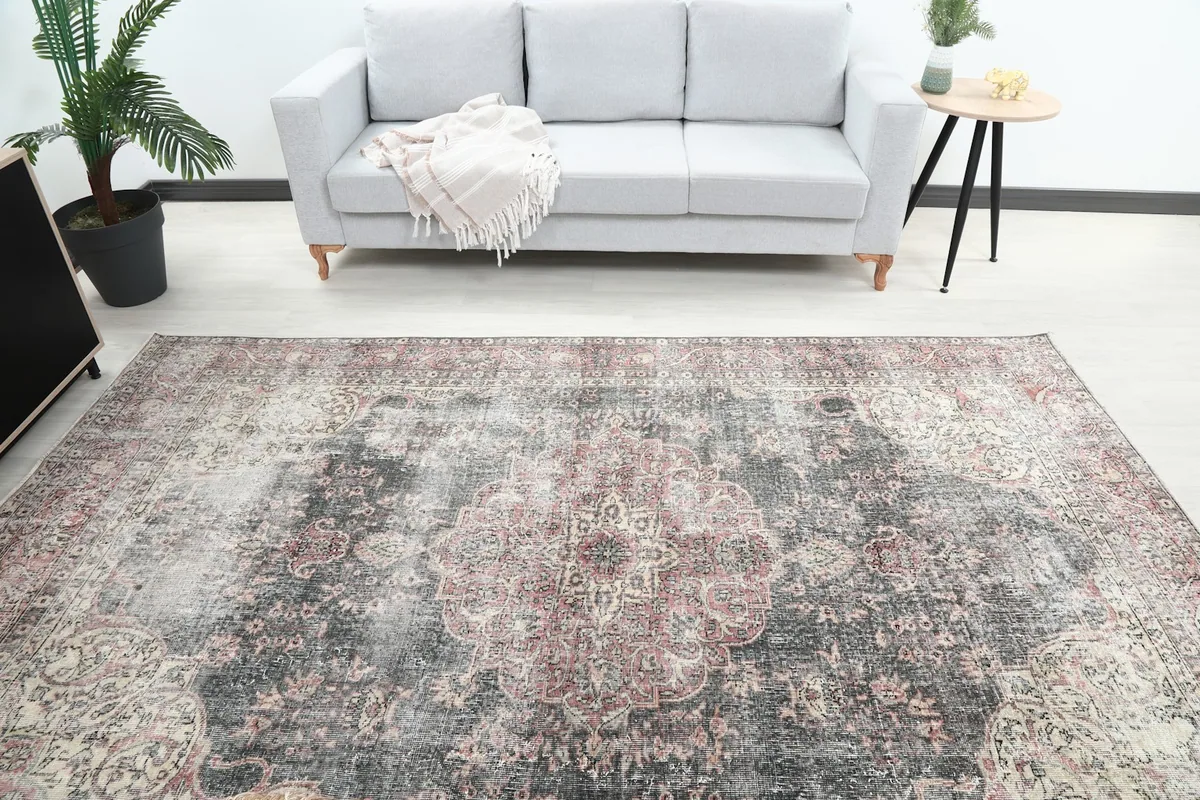 Overhead view of the large vintage rug in a living room, showing its placement relative to a sofa.