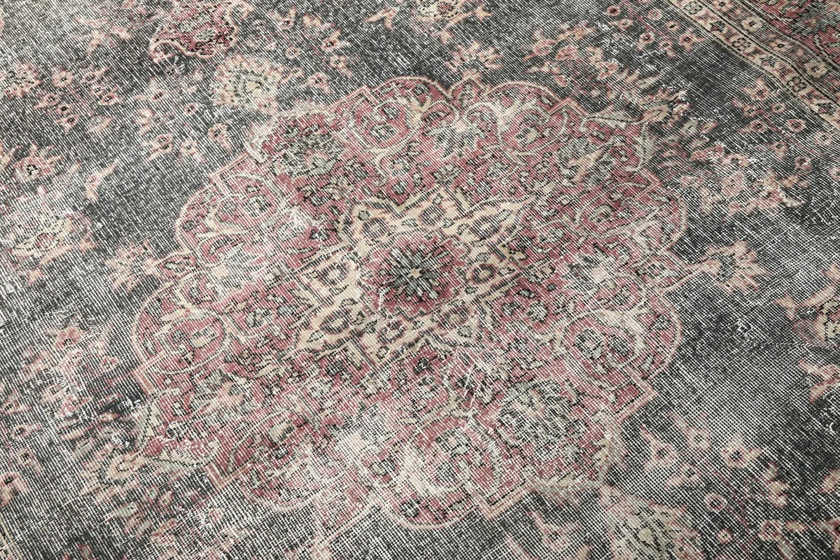 Detailed close-up of the central rose medallion and surrounding charcoal patterns on the rug.