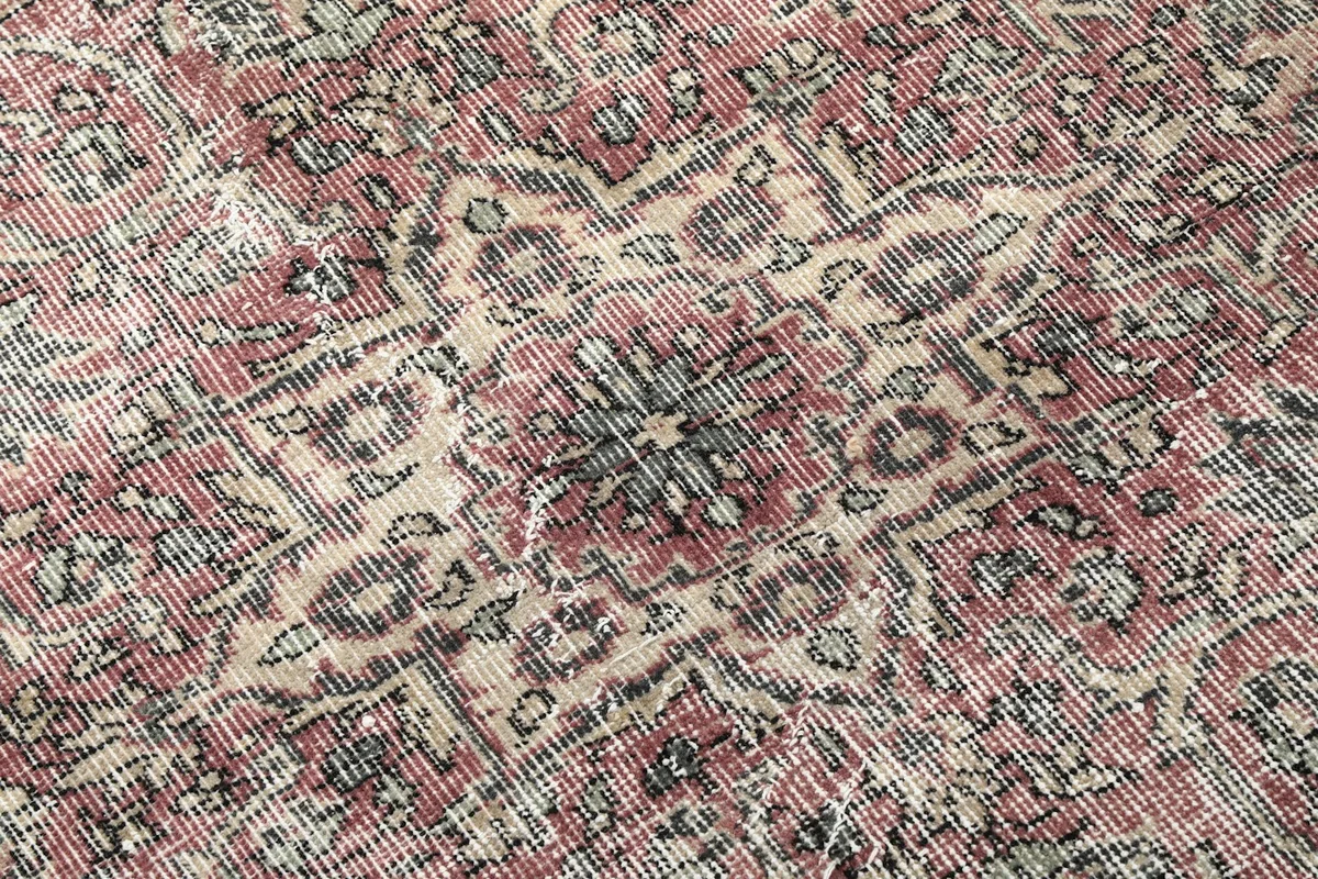 Close-up of the low wool pile, showing the hand-knotted texture and distressed appearance.