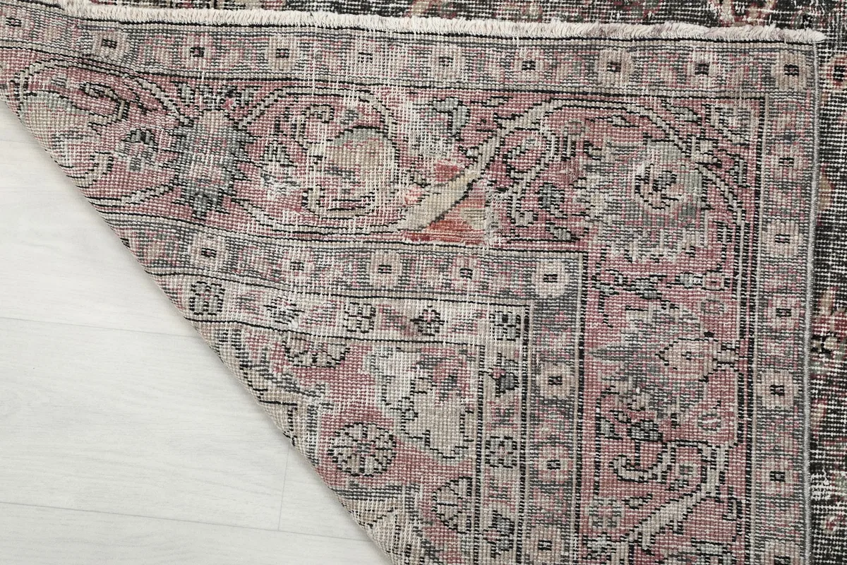 Underside of the rug's corner, showing the tight hand-knotting and cotton foundation.