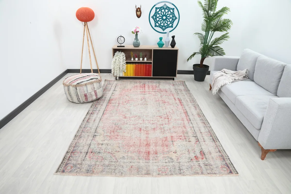 Vintage rug displayed in a living room setting with a light gray sofa and modern decor