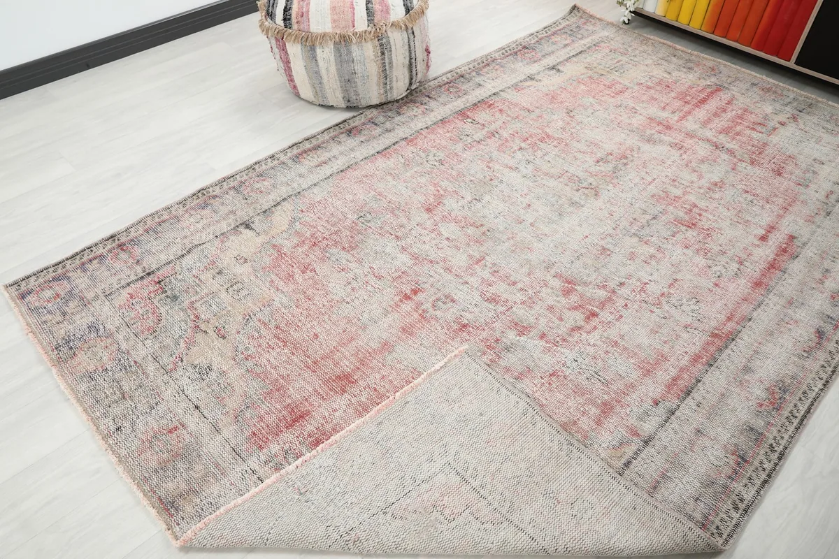 Corner of the rug folded back, showing the cotton foundation and the reverse side of the knots