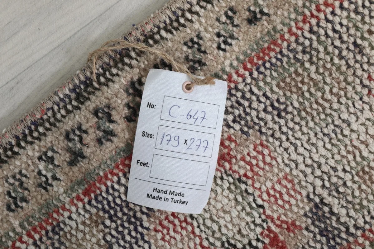 Tag showing the rug's dimensions in centimeters and confirming it is hand made in Turkey