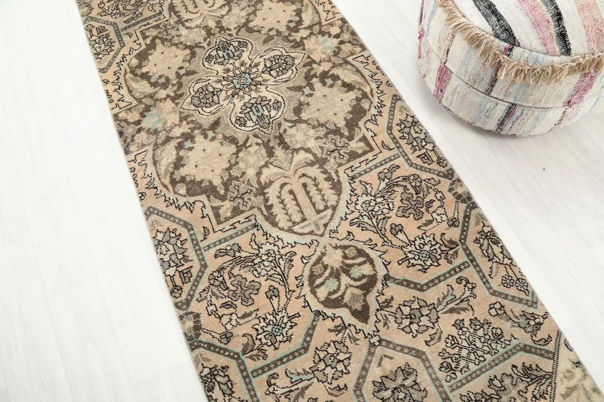 Diagonal view of the runner rug, emphasizing the blend of beige, brown, and subtle blue in its design