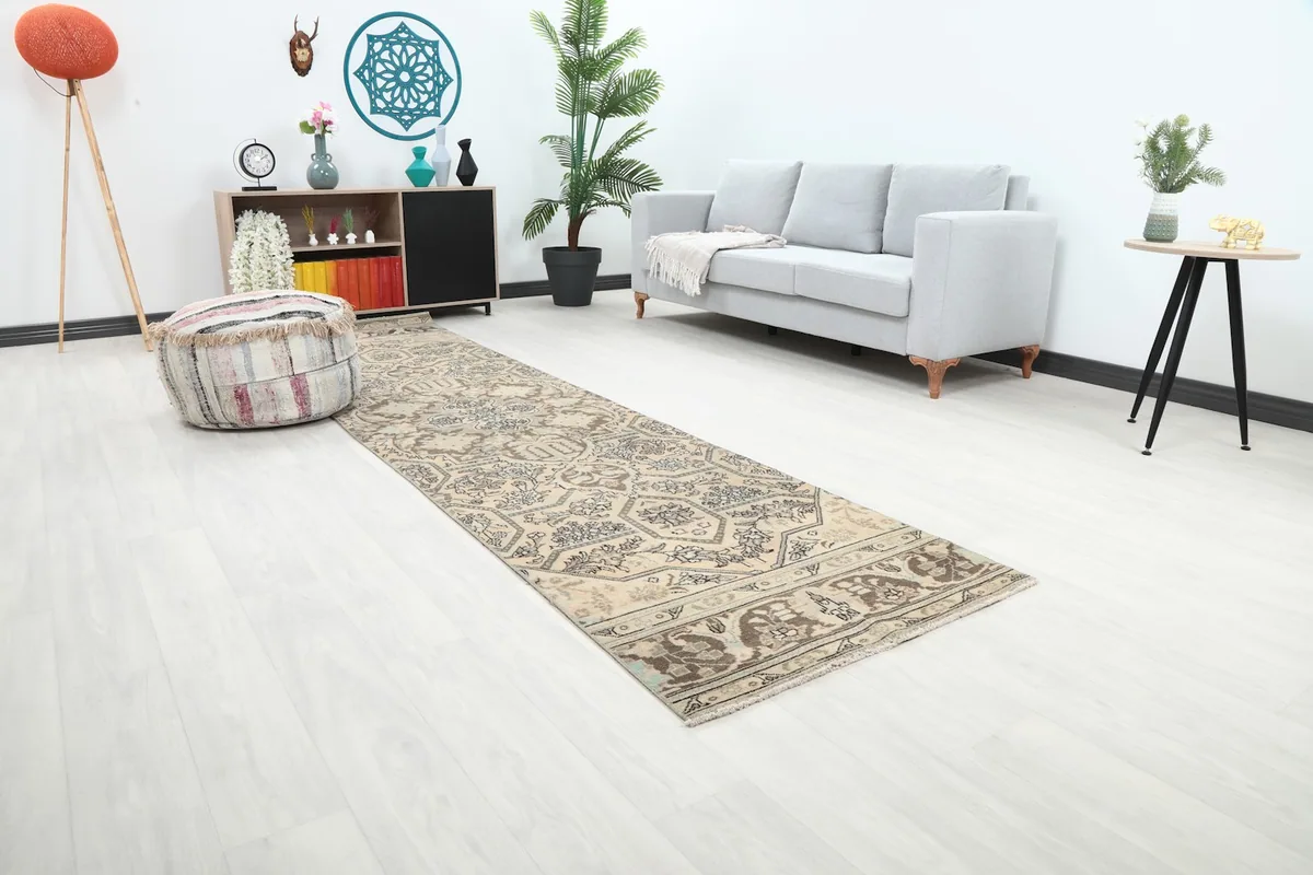 Angle view of the runner rug in a room, showing its length and neutral tones against white flooring