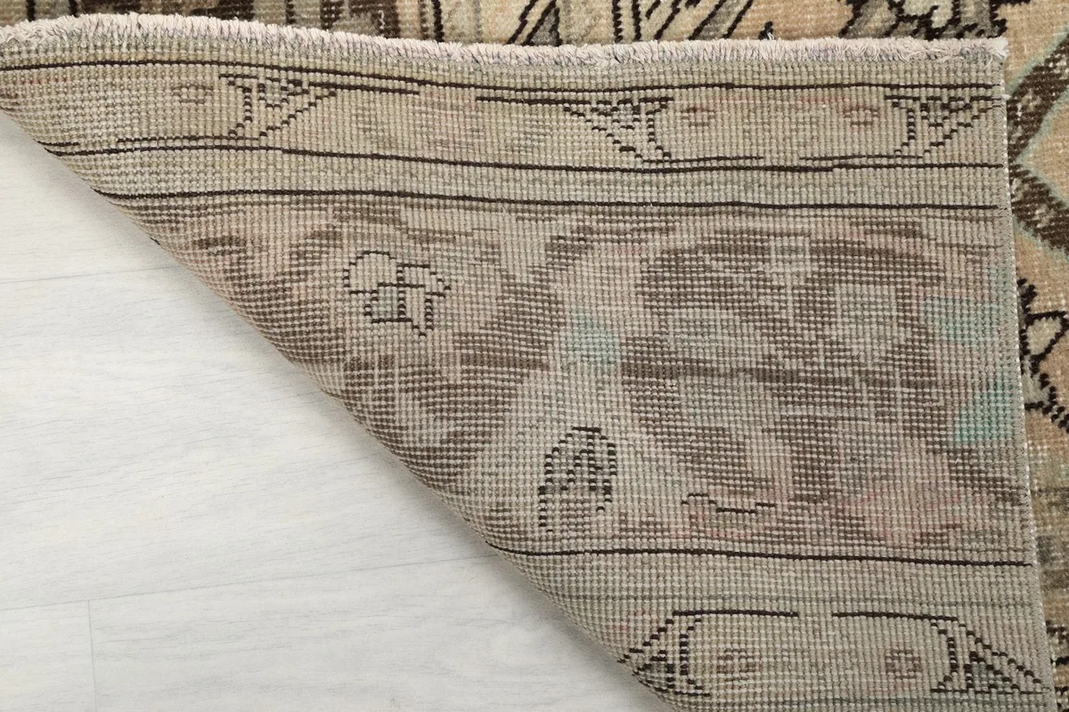 Another view of the rug's corner folded, showing the quality of the hand-knotted construction and fringe